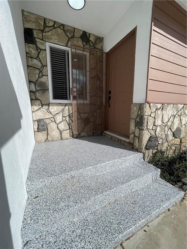 property entrance with stone siding