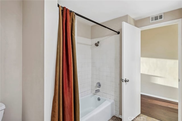 full bathroom featuring visible vents, toilet, and shower / tub combo