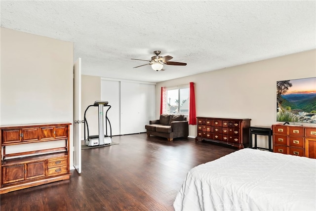 bedroom featuring ceiling fan, a closet, a textured ceiling, and dark wood finished floors