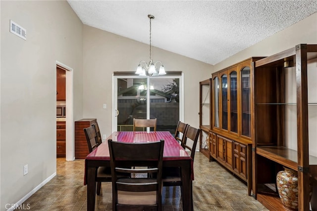 dining room featuring a chandelier, visible vents, a textured ceiling, and lofted ceiling