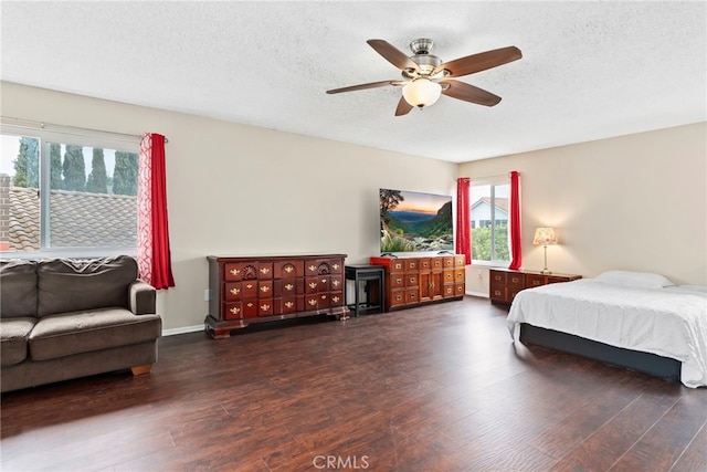 bedroom featuring baseboards, a textured ceiling, a ceiling fan, and wood finished floors