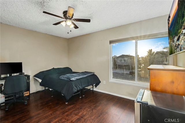 bedroom featuring a textured ceiling, a ceiling fan, baseboards, and wood finished floors