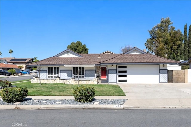 ranch-style house featuring a porch, concrete driveway, an attached garage, and a front lawn