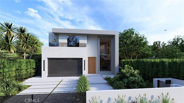 modern home featuring a garage, fence, and stucco siding