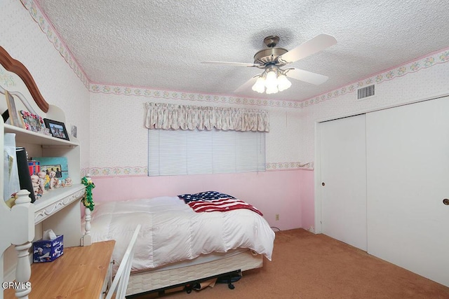 bedroom with visible vents, a ceiling fan, a textured ceiling, carpet flooring, and a closet