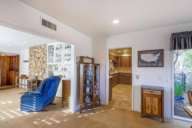 living area with recessed lighting, visible vents, and light colored carpet