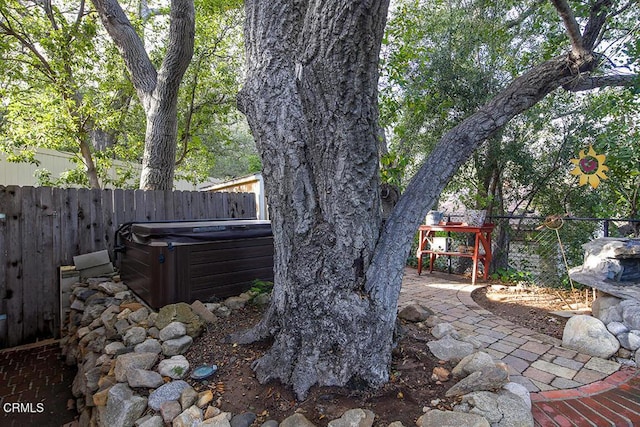 view of yard with cooling unit, a fenced backyard, a patio, and a hot tub