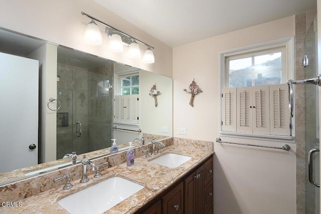 bathroom with double vanity, a stall shower, and a sink