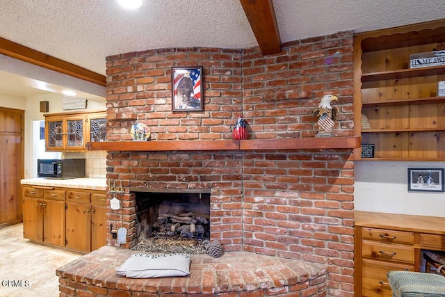 living room with a textured ceiling, a brick fireplace, and beam ceiling