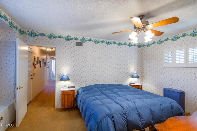 bedroom with a textured ceiling, light carpet, a ceiling fan, visible vents, and wallpapered walls