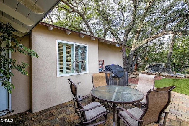 view of patio / terrace with a grill, fence, and outdoor dining space