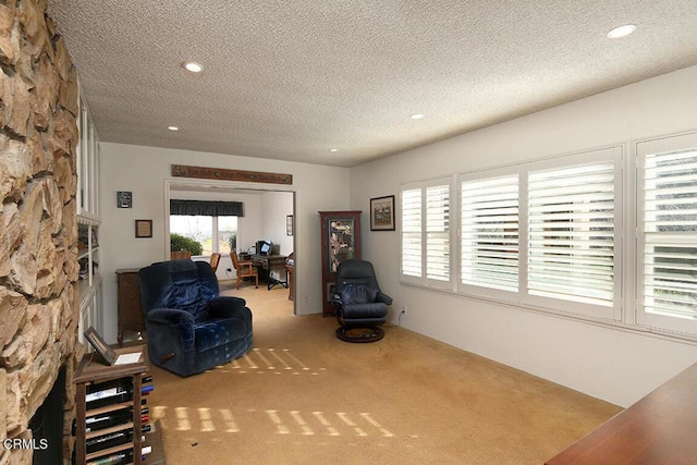 unfurnished room featuring carpet, a stone fireplace, a textured ceiling, and recessed lighting