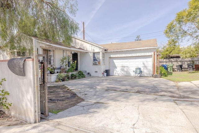 ranch-style home with fence, concrete driveway, stucco siding, cooling unit, and a garage