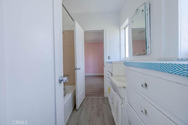 bathroom featuring bathtub / shower combination, wood finished floors, and vanity