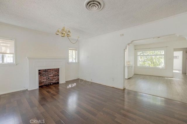 unfurnished living room with plenty of natural light, wood finished floors, and visible vents