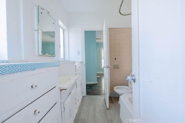 full bath featuring vanity, toilet, wood finished floors, and a healthy amount of sunlight