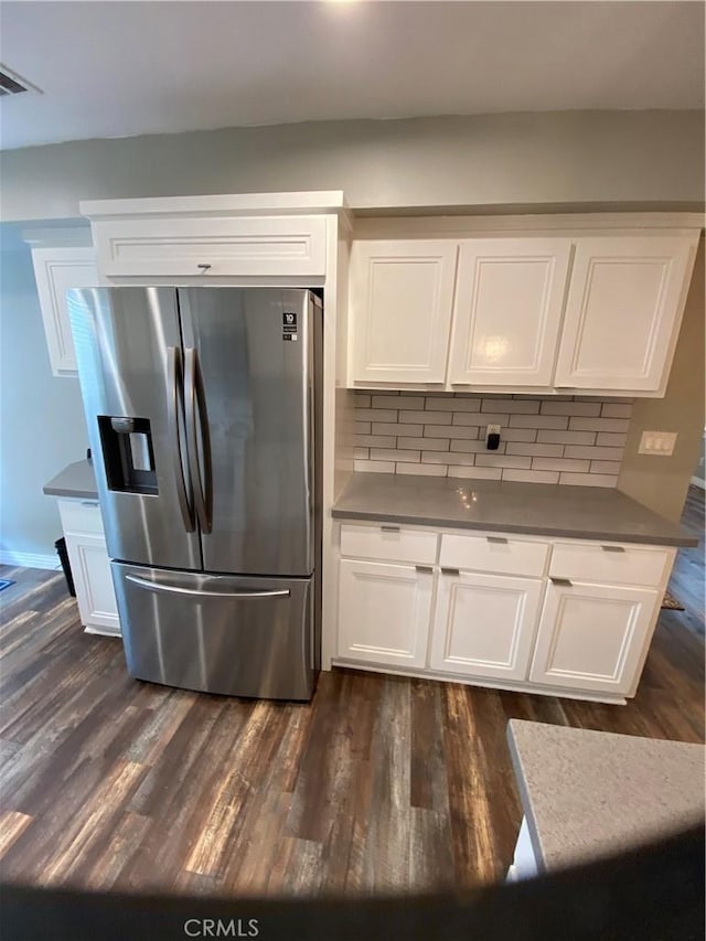 kitchen featuring stainless steel fridge, white cabinets, and dark wood-type flooring