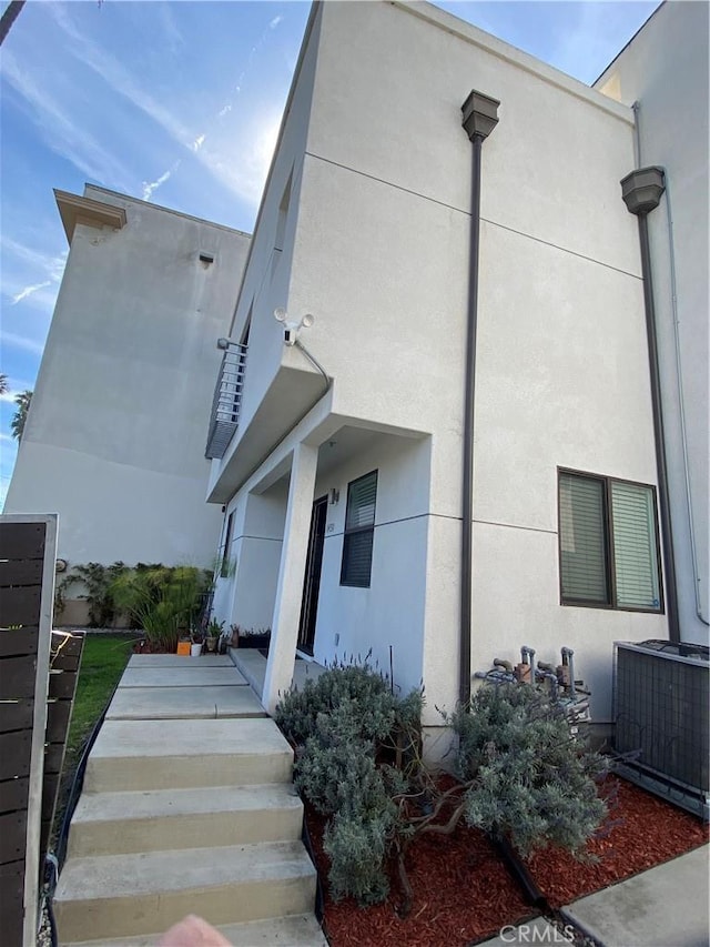 view of side of home featuring stucco siding and central air condition unit