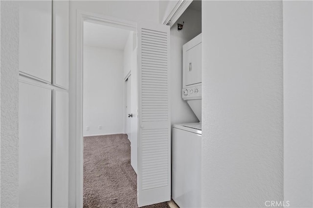 laundry room featuring carpet, stacked washer and clothes dryer, and laundry area