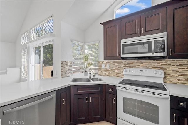 kitchen featuring lofted ceiling, stainless steel appliances, a sink, and light countertops