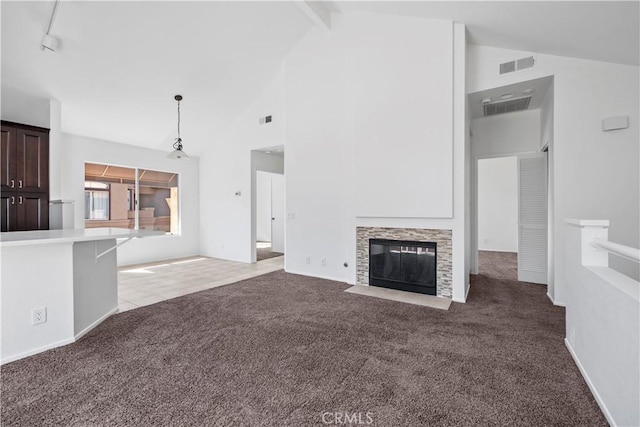 unfurnished living room with beam ceiling, carpet flooring, a fireplace, and visible vents