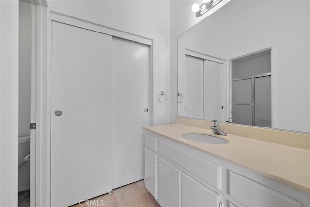 bathroom with tile patterned flooring, vanity, and an enclosed shower