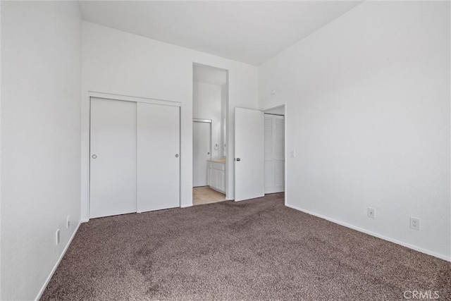 unfurnished bedroom with ensuite bath, carpet, and a closet