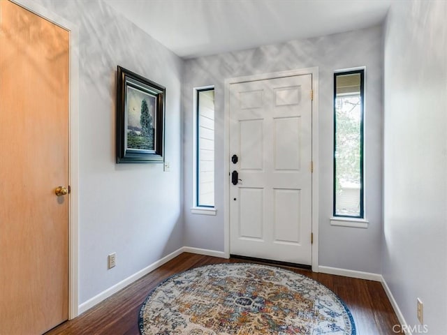 foyer featuring dark wood-style floors and baseboards