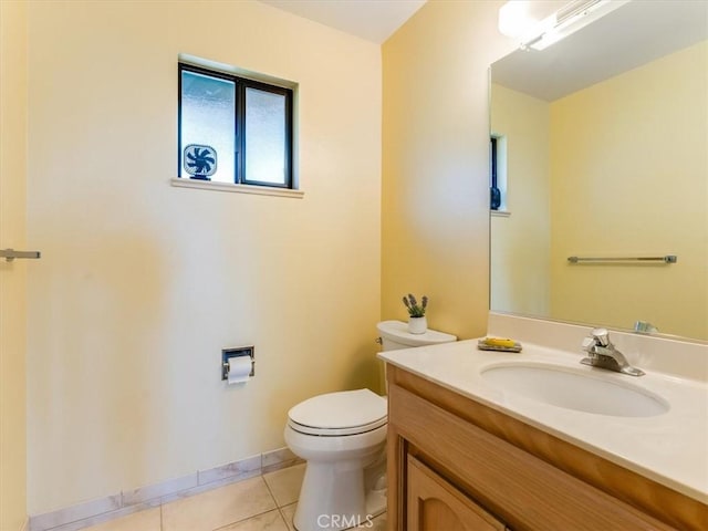 half bath with toilet, tile patterned flooring, baseboards, and vanity