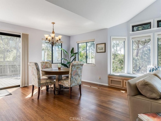 dining area with baseboards, vaulted ceiling, an inviting chandelier, and wood finished floors