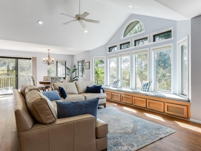 living area with a healthy amount of sunlight, light wood-style flooring, high vaulted ceiling, and recessed lighting