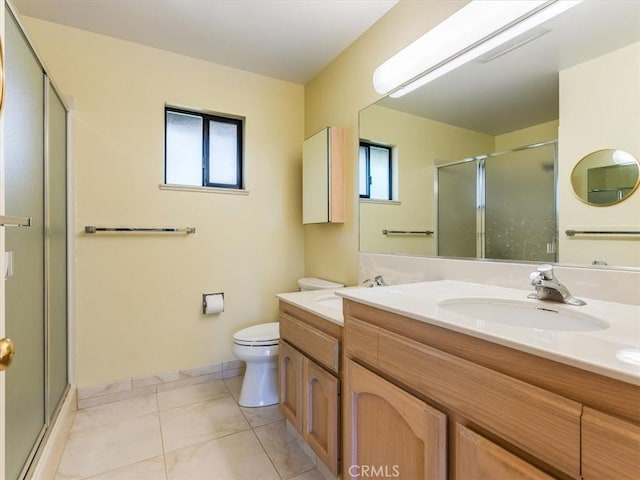 bathroom featuring double vanity, toilet, a stall shower, a sink, and tile patterned floors