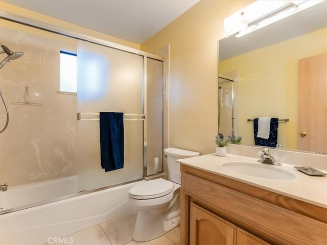 full bath with tile patterned flooring, vanity, toilet, and bath / shower combo with glass door