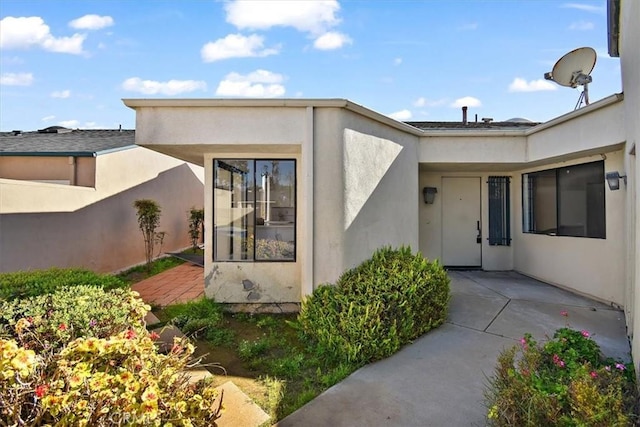 view of exterior entry featuring stucco siding