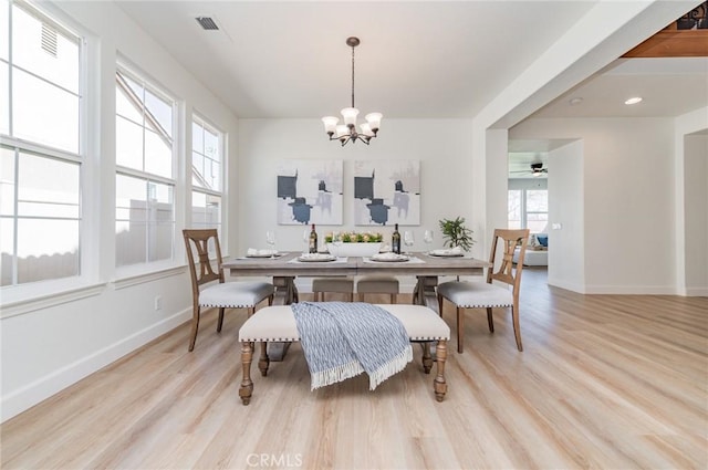 dining area with visible vents, wood finished floors, baseboards, and a chandelier