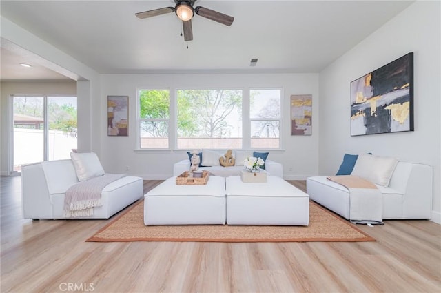 living room with a ceiling fan, wood finished floors, and baseboards