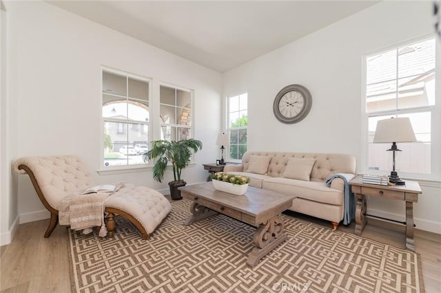 living area with light wood-type flooring and baseboards