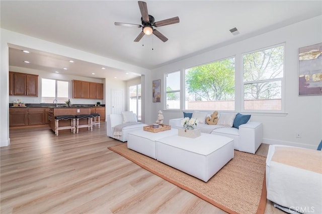 living area with a wealth of natural light, visible vents, light wood-type flooring, and recessed lighting