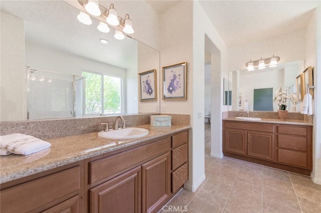 bathroom featuring a sink, two vanities, a stall shower, and tile patterned flooring