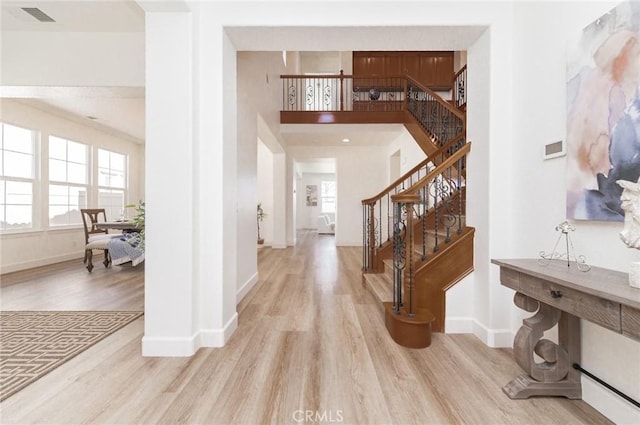 foyer with wood finished floors, visible vents, and baseboards