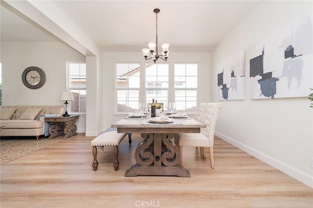 dining space with a notable chandelier, wood finished floors, and baseboards