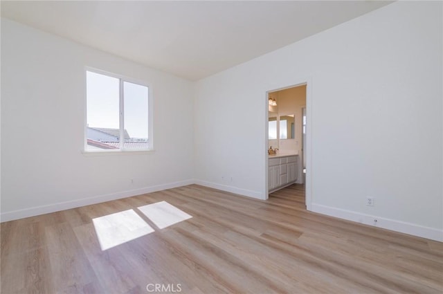 spare room featuring light wood-style flooring and baseboards