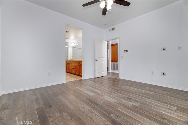 unfurnished room with visible vents, baseboards, and wood finished floors