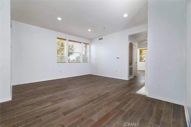 unfurnished room with baseboards, dark wood-style flooring, and recessed lighting