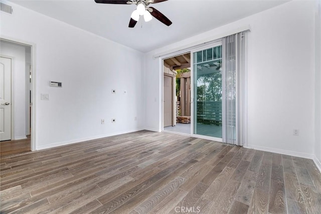 unfurnished room with a ceiling fan, visible vents, baseboards, and wood finished floors