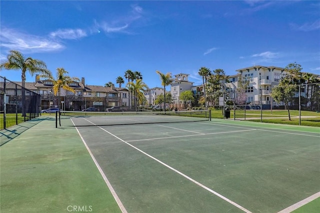 view of sport court with fence and a residential view