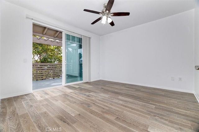 unfurnished room with a ceiling fan, baseboards, and wood finished floors