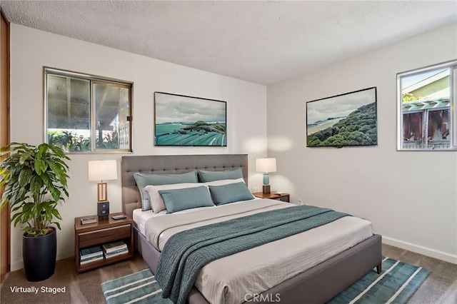 bedroom featuring carpet flooring, a textured ceiling, and baseboards