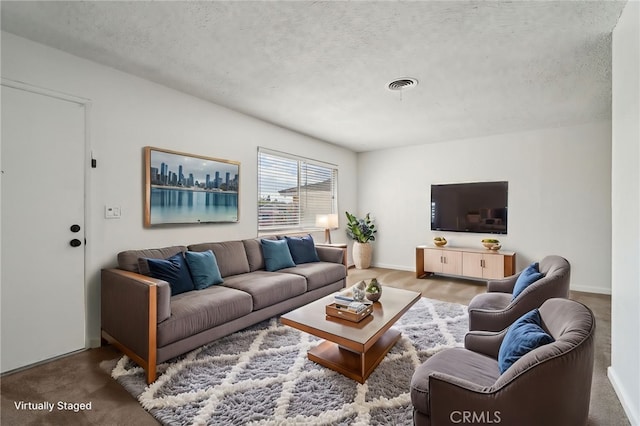 living area featuring baseboards, visible vents, and a textured ceiling