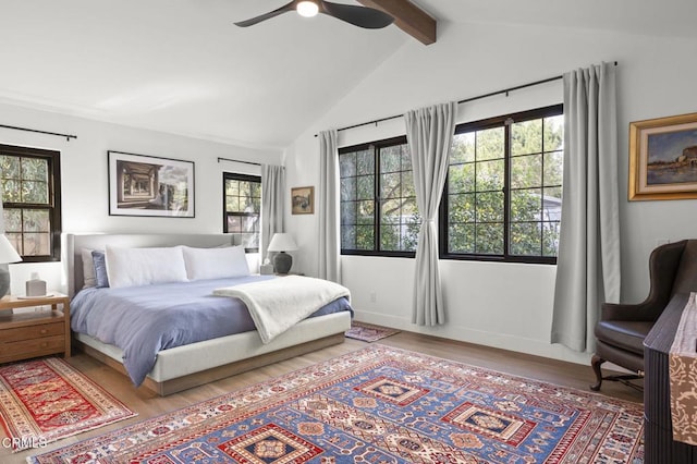 bedroom with a ceiling fan, vaulted ceiling with beams, baseboards, and wood finished floors